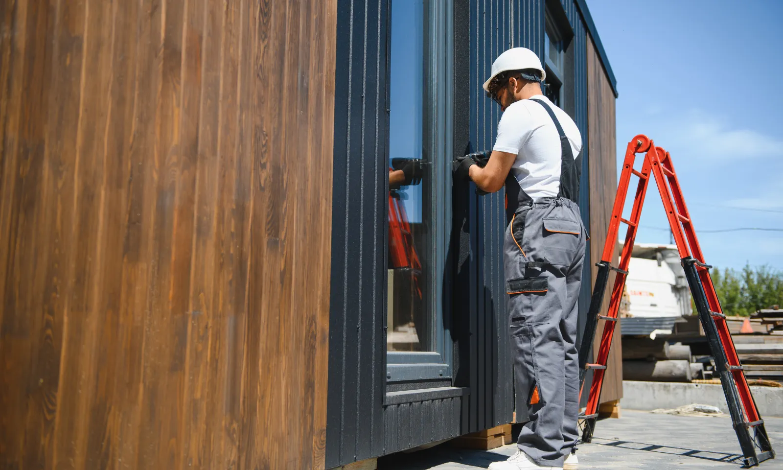 Contractors completing exterior siding installation on prefabricated ADU during backyard installation in Los Angeles California